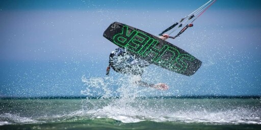 Kitesurfer performing a trick above the water